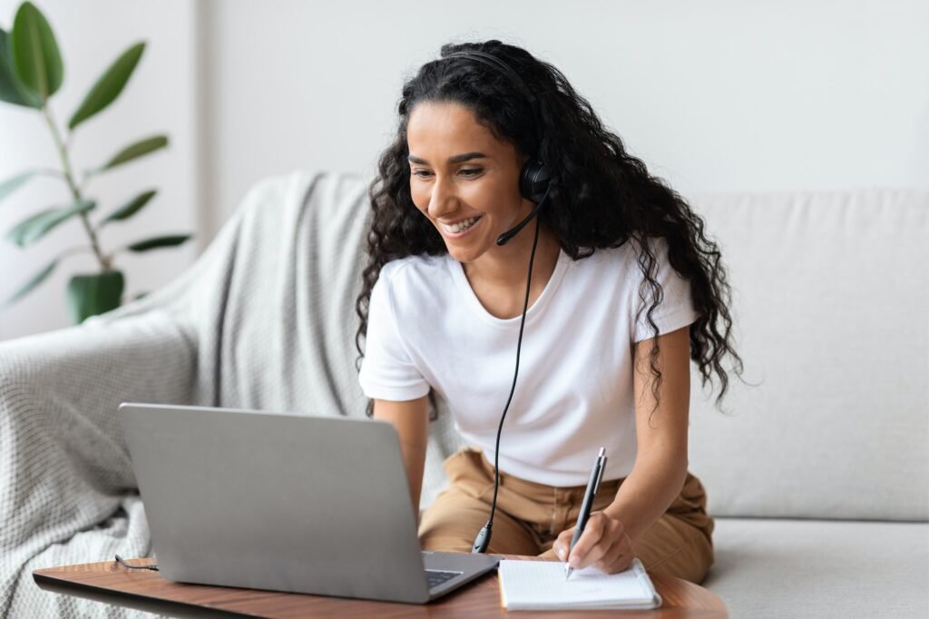 joyful young woman studying online using laptop at home